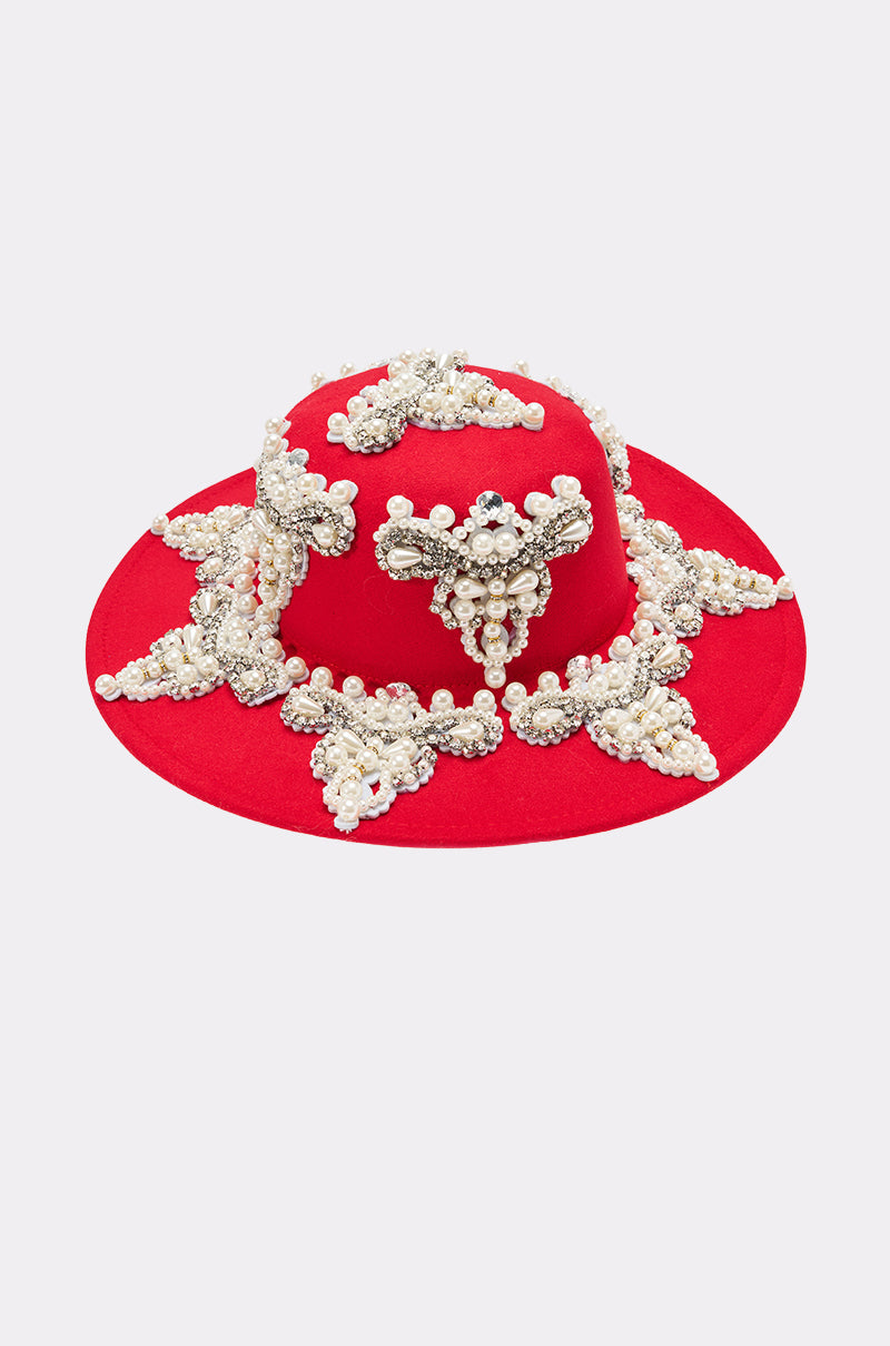 The EDITORS PICK APPLIQUE BRIM HAT is a bright red hat with a wide brim, featuring ornate clusters of white pearls and sparkling rhinestones arranged in symmetrical patterns. 3