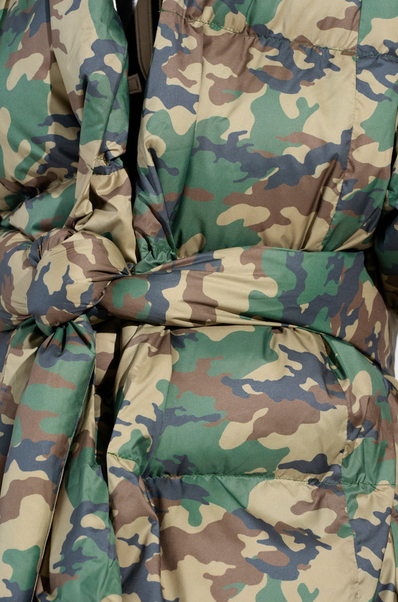 This close-up highlights the CAMO LONG RIB SLEEVE PEPLUM PUFFER COAT, showcasing its shades of green, brown, and beige with ribbed sleeves and a tied belt at the waist.