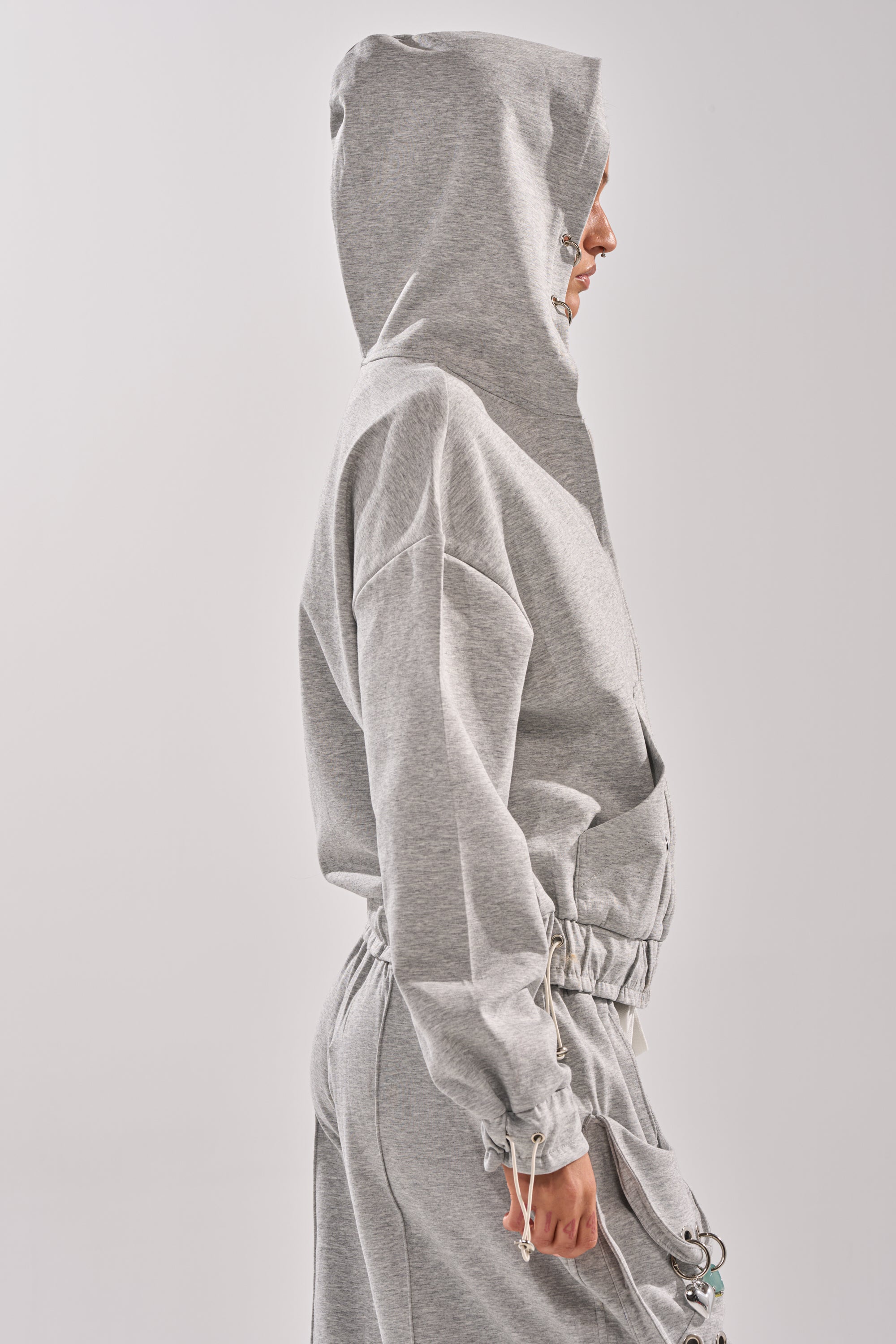 A person in profile wears the GET WITH IT ZIP UP SWEATSHIRT and matching gray drawstring sweatpants, set against a plain light background. 5
