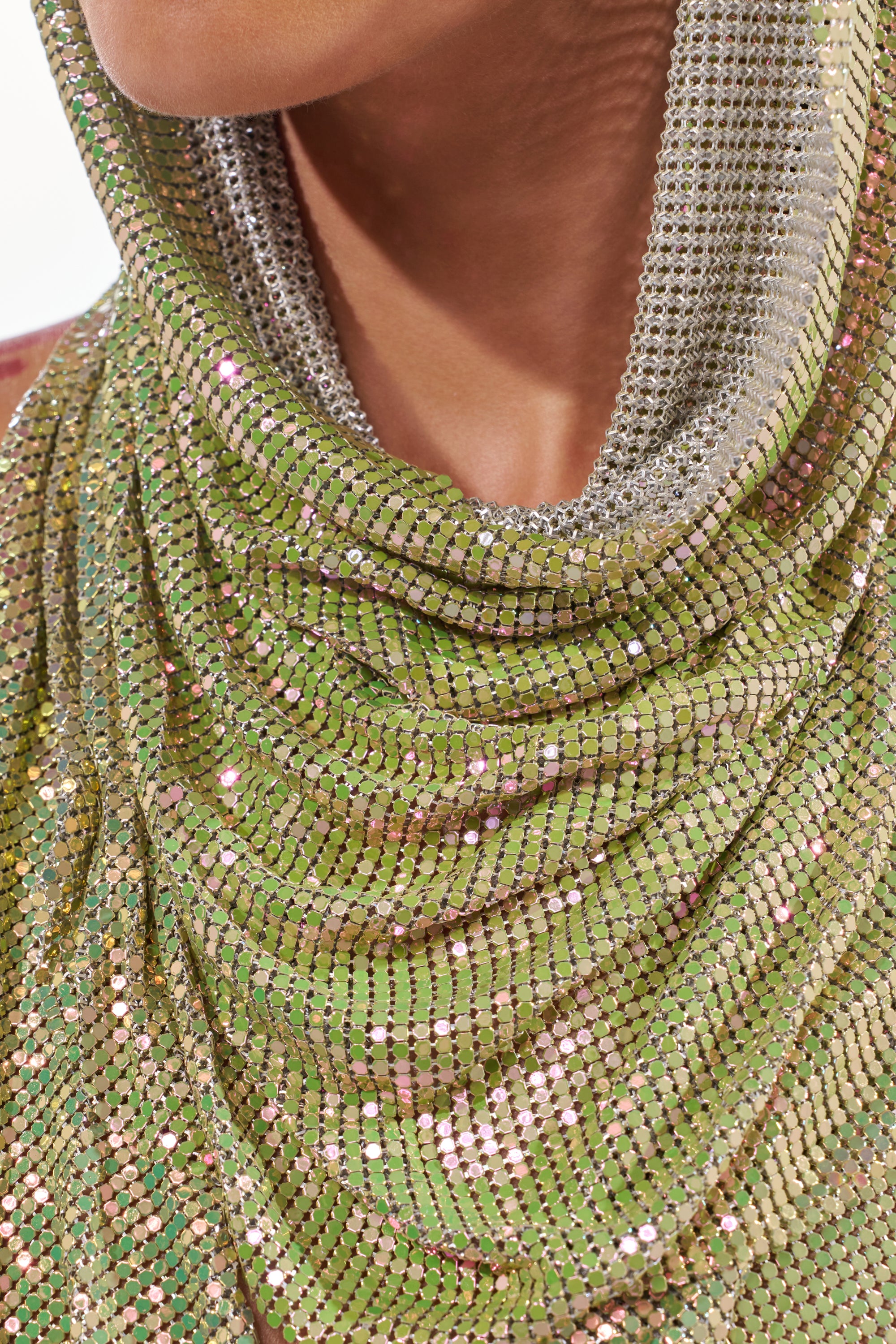 A close-up shot shows a person wearing the IN MY MIND HOODED CHAINMAIL TOP IN GREEN, its shimmering sequins in green and silver reflecting light. Only the lower face and neck are visible. 8
