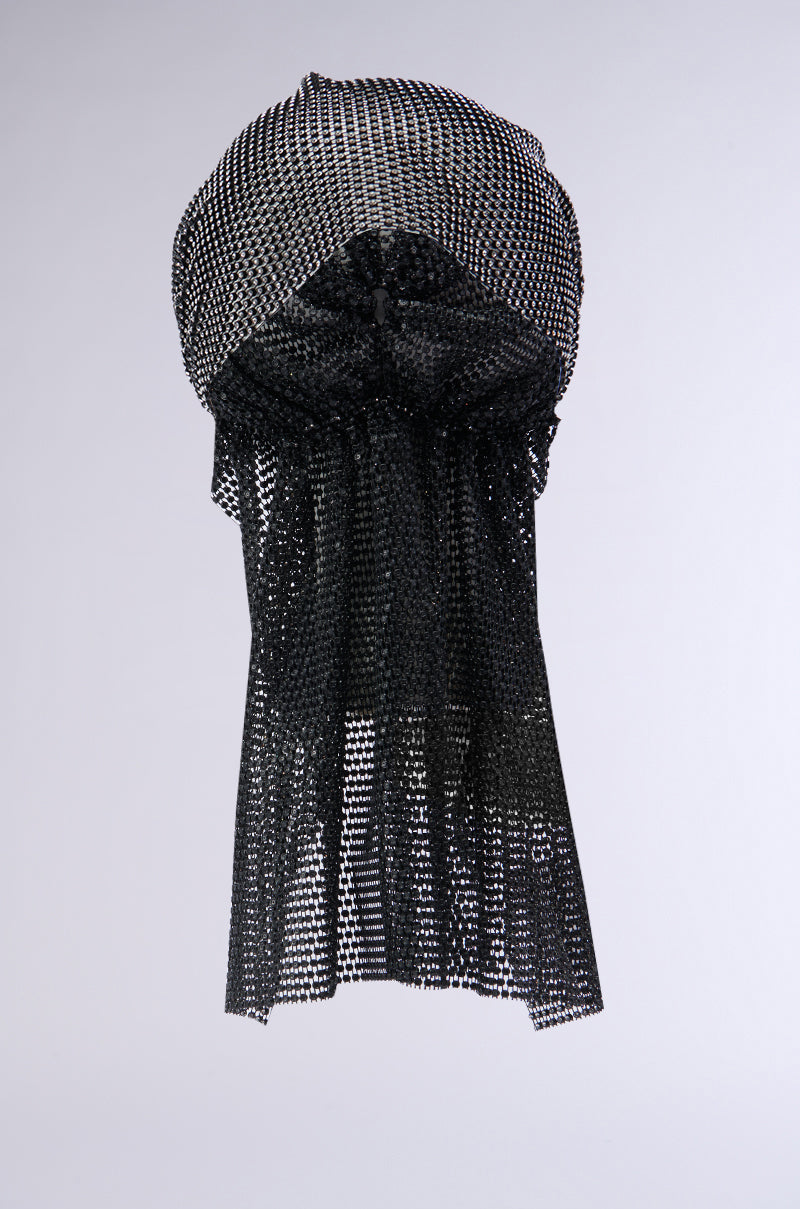 The ELEGANCE IS EARNED HEADPIECE, a black, loosely woven mesh fabric sculpture, is suspended in mid-air, forming a dome-like shape at the top that tapers down into a cascading, irregular form. The intricate texture features tiny square openings that resemble net-like rhinestone mesh against a plain gray background.