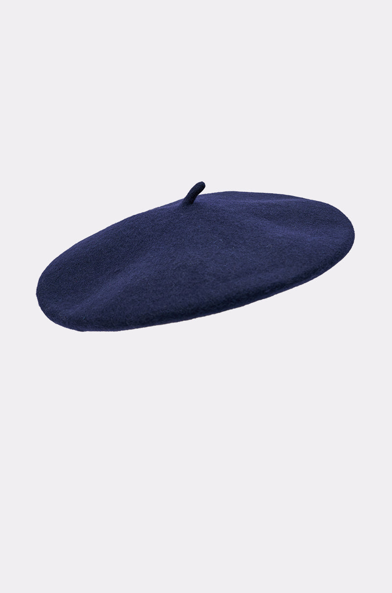 The TOO COZY NAVY BERET is a classic navy hat featuring a small stalk on top, crafted from wool-like material and shown against a plain light gray background. 3