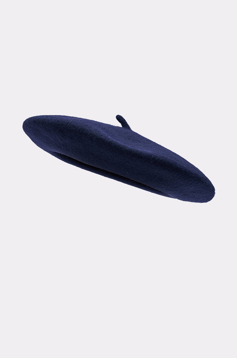 The TOO COZY NAVY BERET, featuring a small top stem, is shown in a wool-like fabric against a plain light gray background. 4