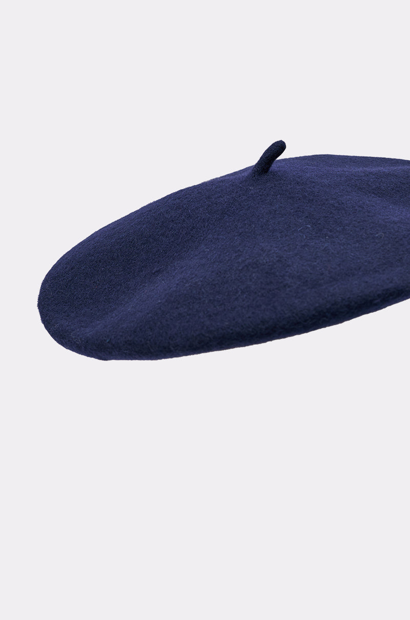 The TOO COZY NAVY BERET features a wool-like texture and a small top stem, shown against a plain light background. 5