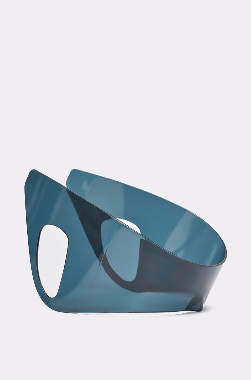 A modern, sculptural blue chair with curved lines sits beside IRVY SUNGLASSES; its bold style matches the statement sunglasses’ contemporary flair against a plain white background. 3