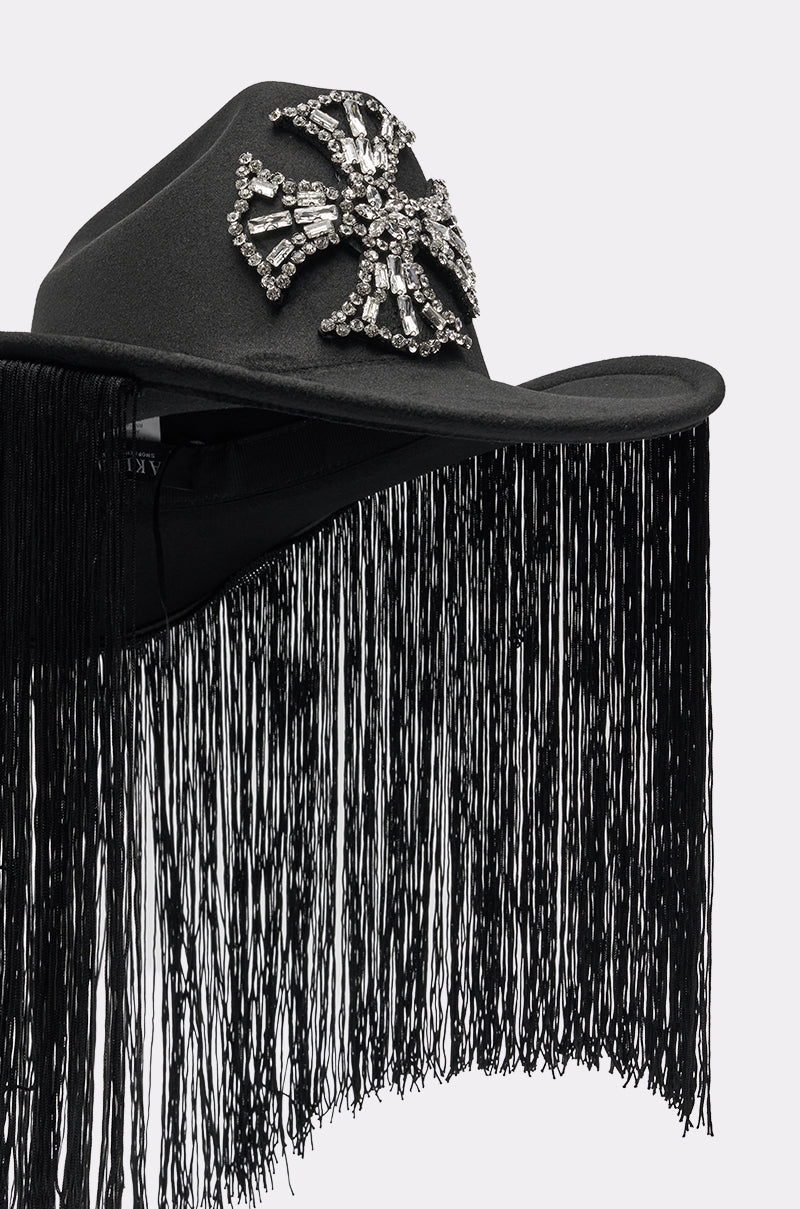 The CALL MY HATERS FRINGE BRIM HAT is a black cowboy hat with a striking rhinestone cross front and long fringe trim cascading from the brim for extra flair. 5