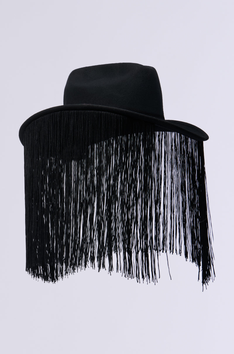 The BE SO FR FRINGE BRIM HAT in black boasts a wide brim and long black fringe, creating a vibrant and textured aesthetic reminiscent of Western fashion. Displayed against a plain white background, it captures attention with its striking design. 4