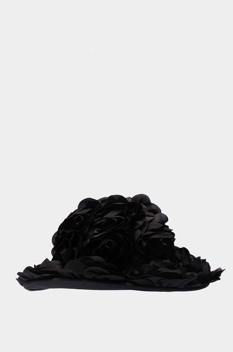 The DARK ROSE FLORAL COWBOY HAT is a dramatic gothic hat with layered, sculpted fabric petals and 3D floral details resembling large blooming flowers, displayed on a plain light gray background.