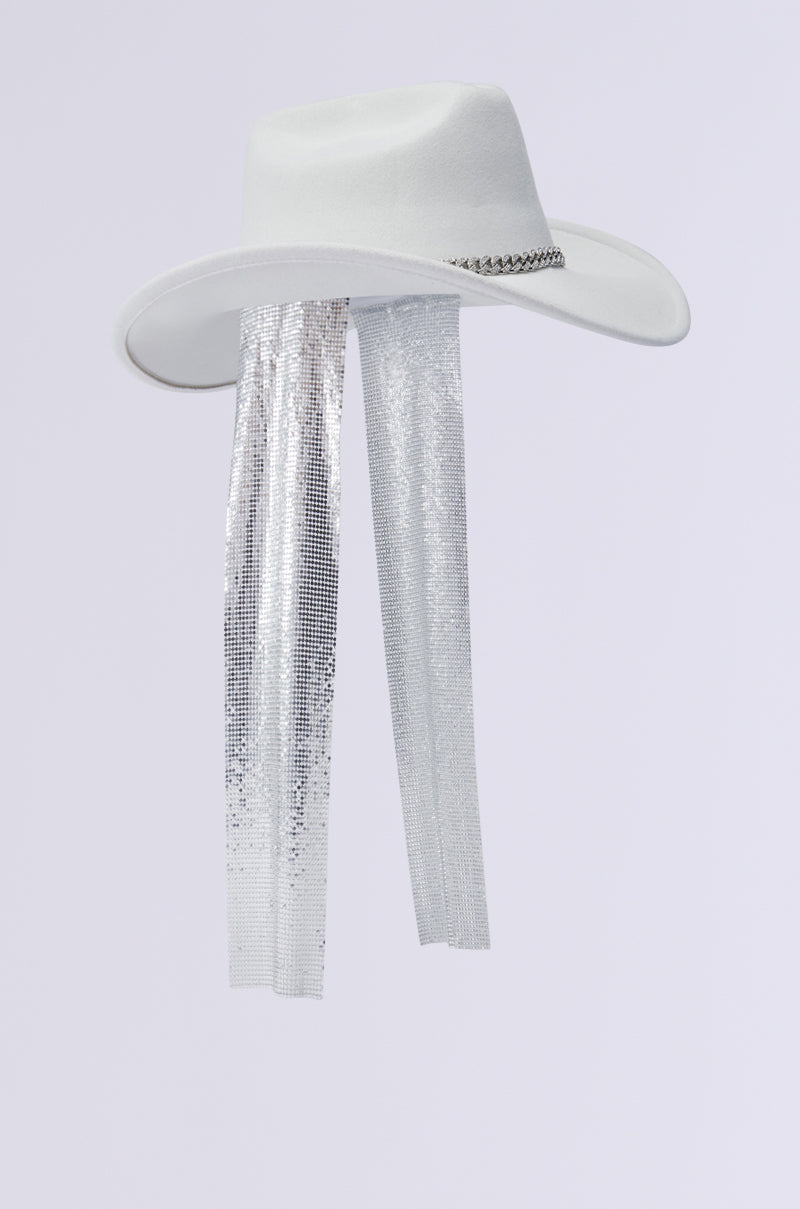 The QUEEN CHAINMAIL COWBOY HAT is a white cowboy hat adorned with a wide brim, a rhinestone-embellished silver chain, and long, dangling silver sequin ribbons, set against a plain white background. 4