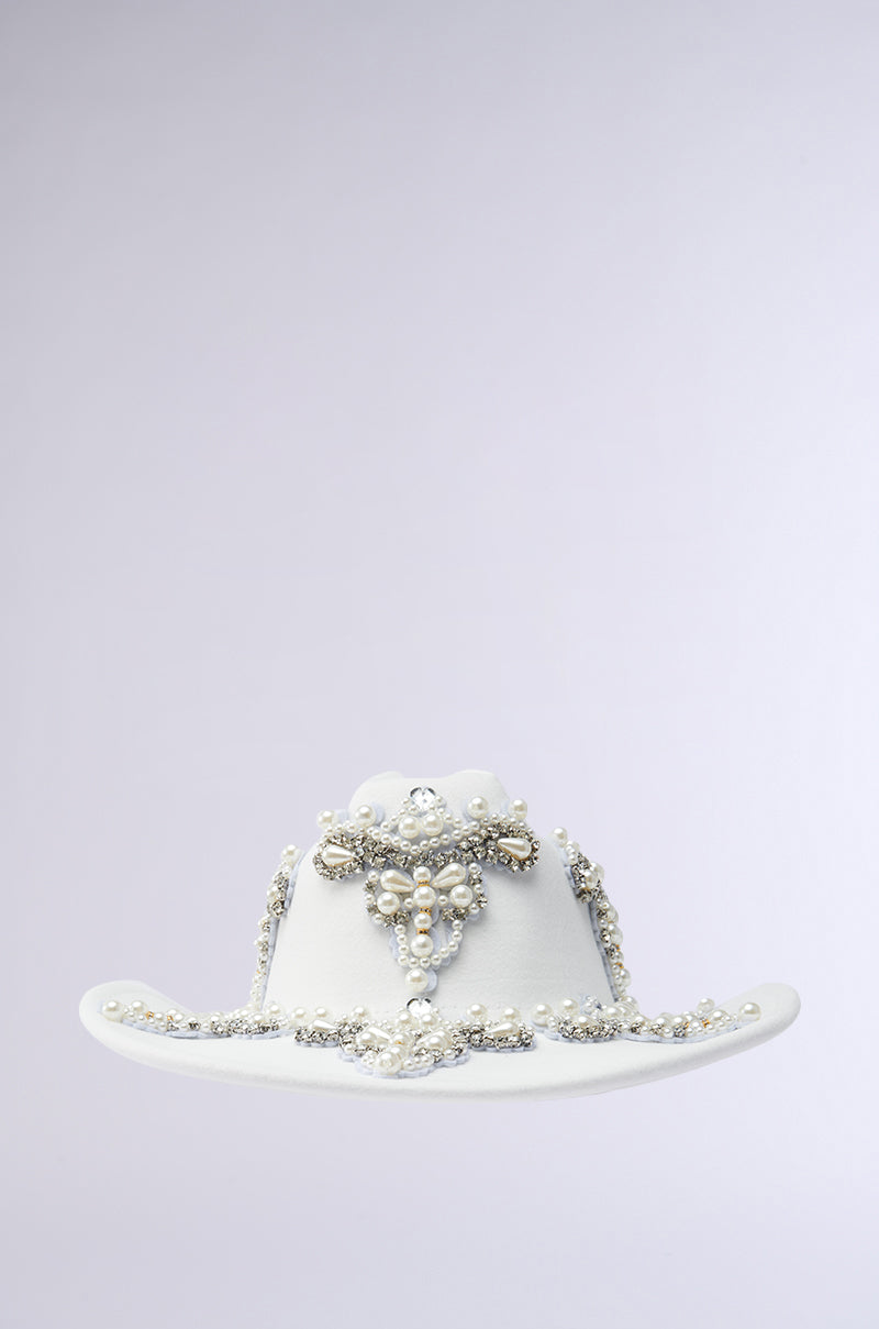 Discover the BOUJEE PEARL COWBOY HAT, a Western piece adorned with beadwork, pearls, and gemstones. Rhinestones enhance its elegant design on a light gray background.