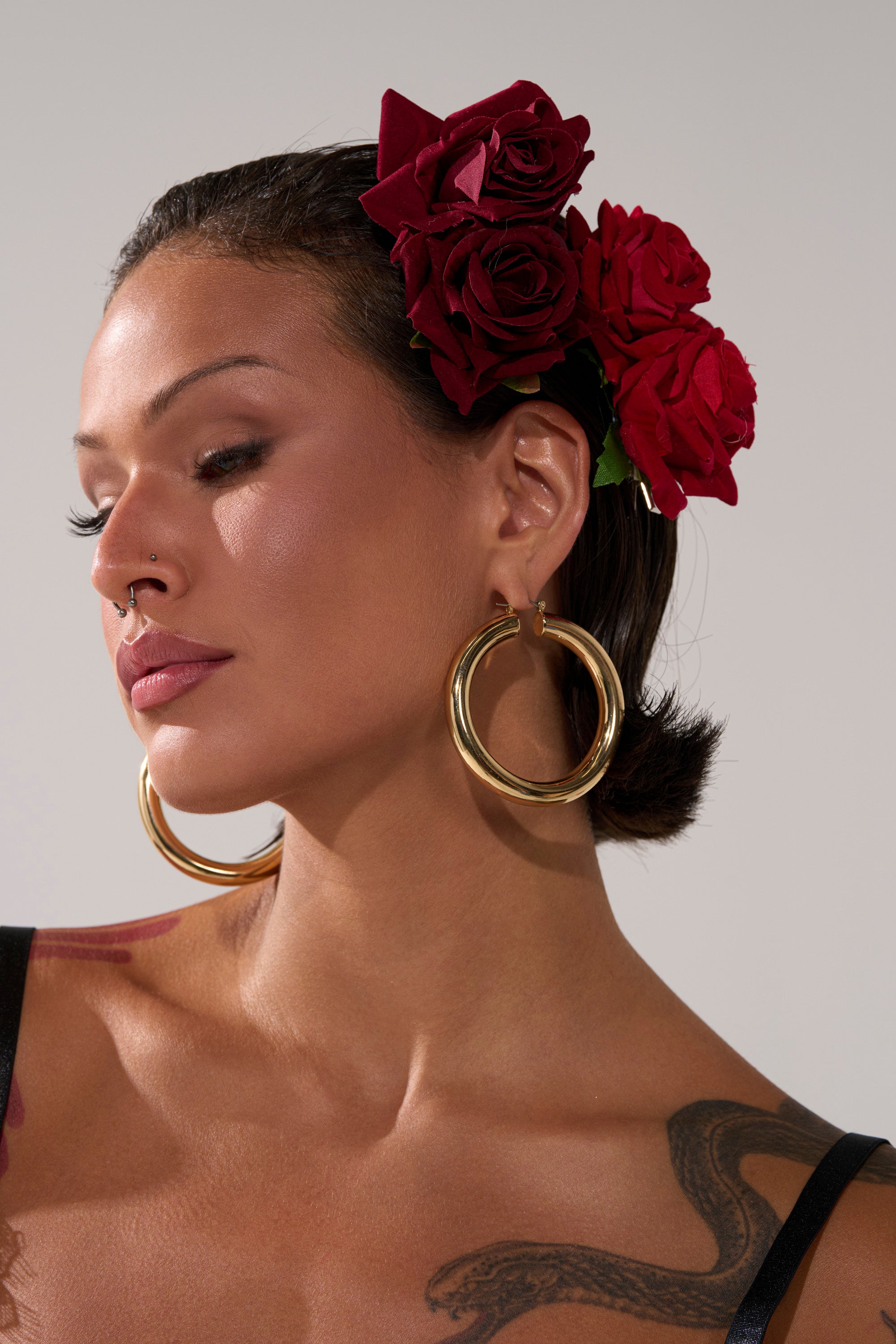 A woman with flowers in her hair, adorned with ROSES ARE RED HAIR CLIPS.