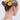 A woman with blonde hair in a neat bun, styled with the LIFE GIVES YOU LEMONS HAIR CLIP SET—lemon and orange-shaped barrettes—wears a gold chain necklace and pink strap top, seen from the back against a plain light background.
