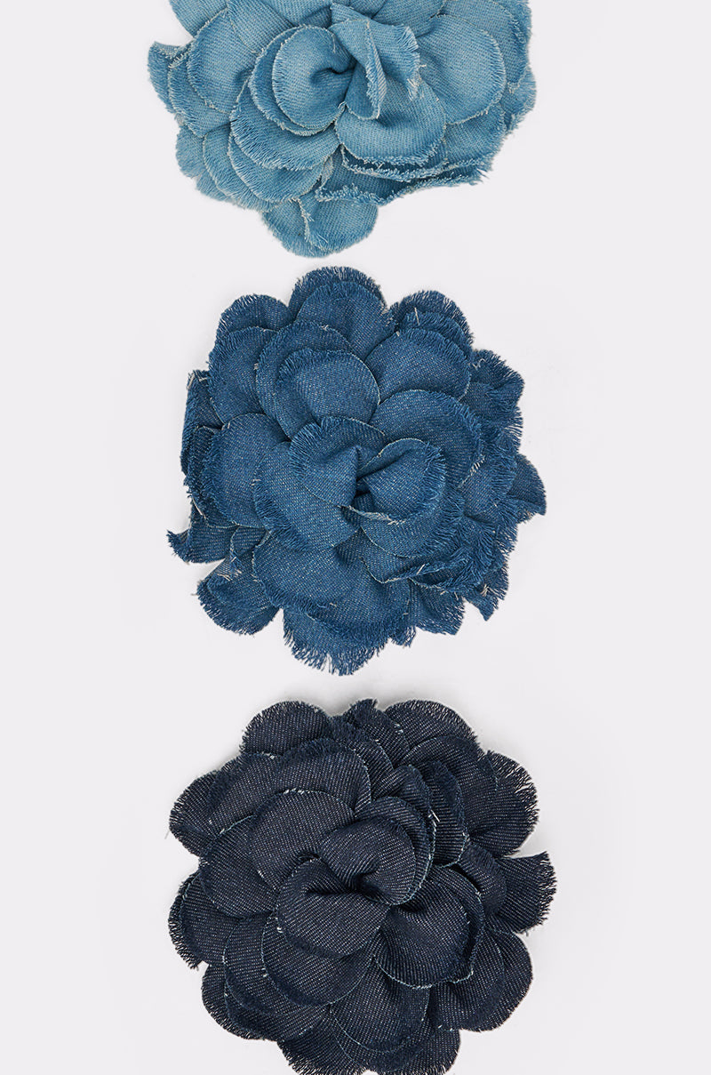 The DENIM ERA BROOCH features three vertically stacked denim flowers—light blue, medium blue, and dark blue—making a chic floral accessory for any outfit. 8