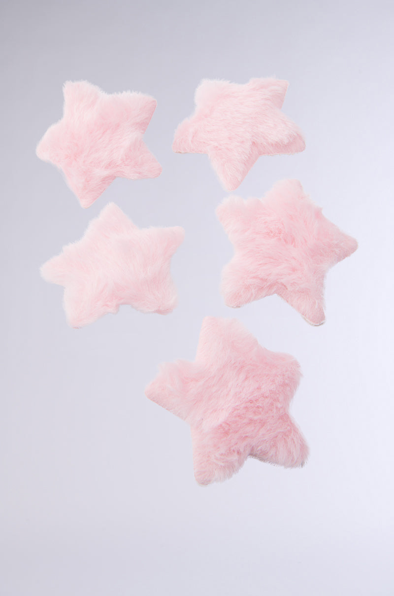 The STAR POWER HAIR CLIP SET includes five fluffy, pastel pink star-shaped clips with alligator fastenings. Their faux fur texture and soft color add a whimsical, cozy vibe. Displayed on a plain light gray background. 2