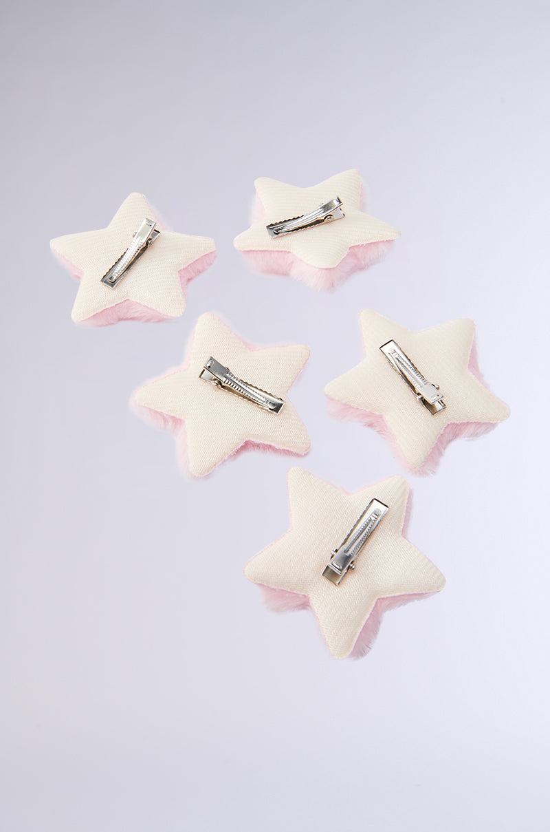 Five white, star-shaped hair clips from the STAR POWER HAIR CLIP SET, each with an alligator clip fastening, are arranged in a scattered pattern on a light gray background. 3