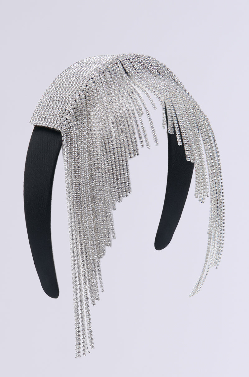Discover the NEVER DRAMATIC BLING HEADBAND, an exquisite accessory featuring a black band embellished with cascading silver rhinestones.