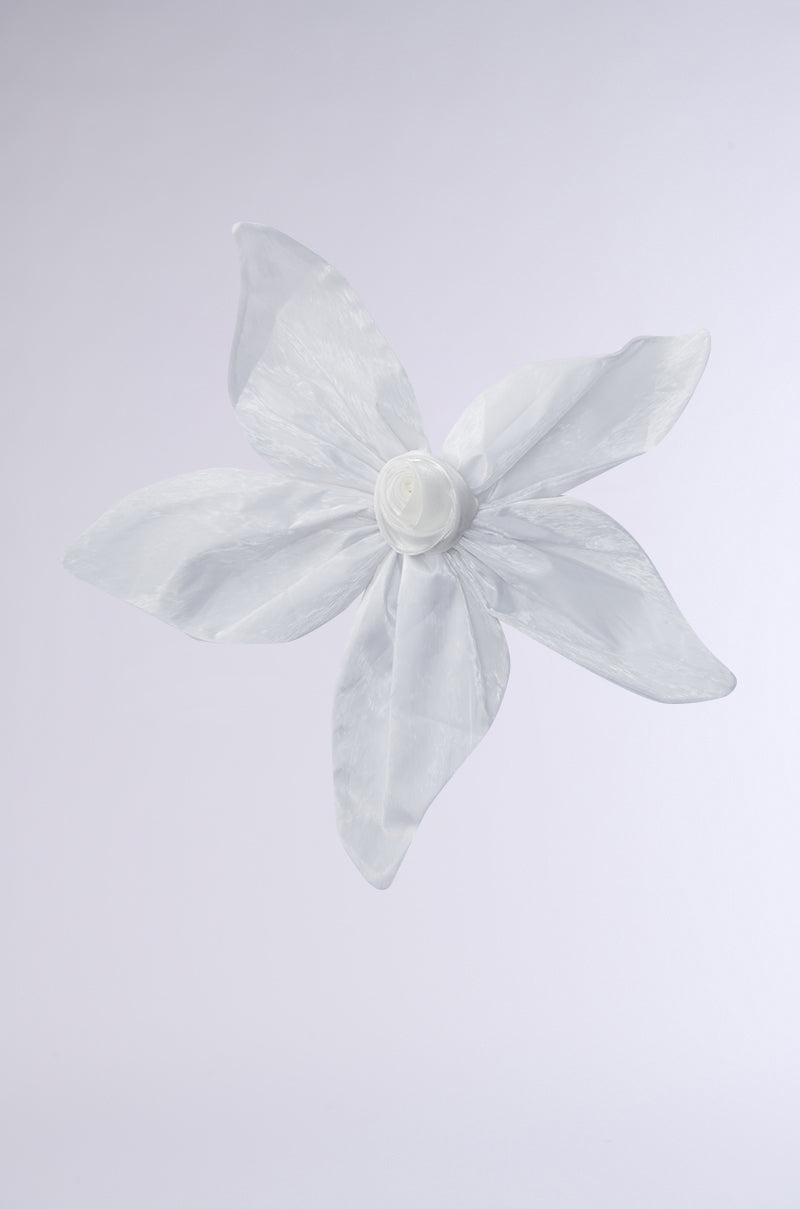 The FLOWER BLOOM BROOCH features five delicate, white petals crafted from translucent fabric with a rolled center, displayed on a plain light gray background. 1