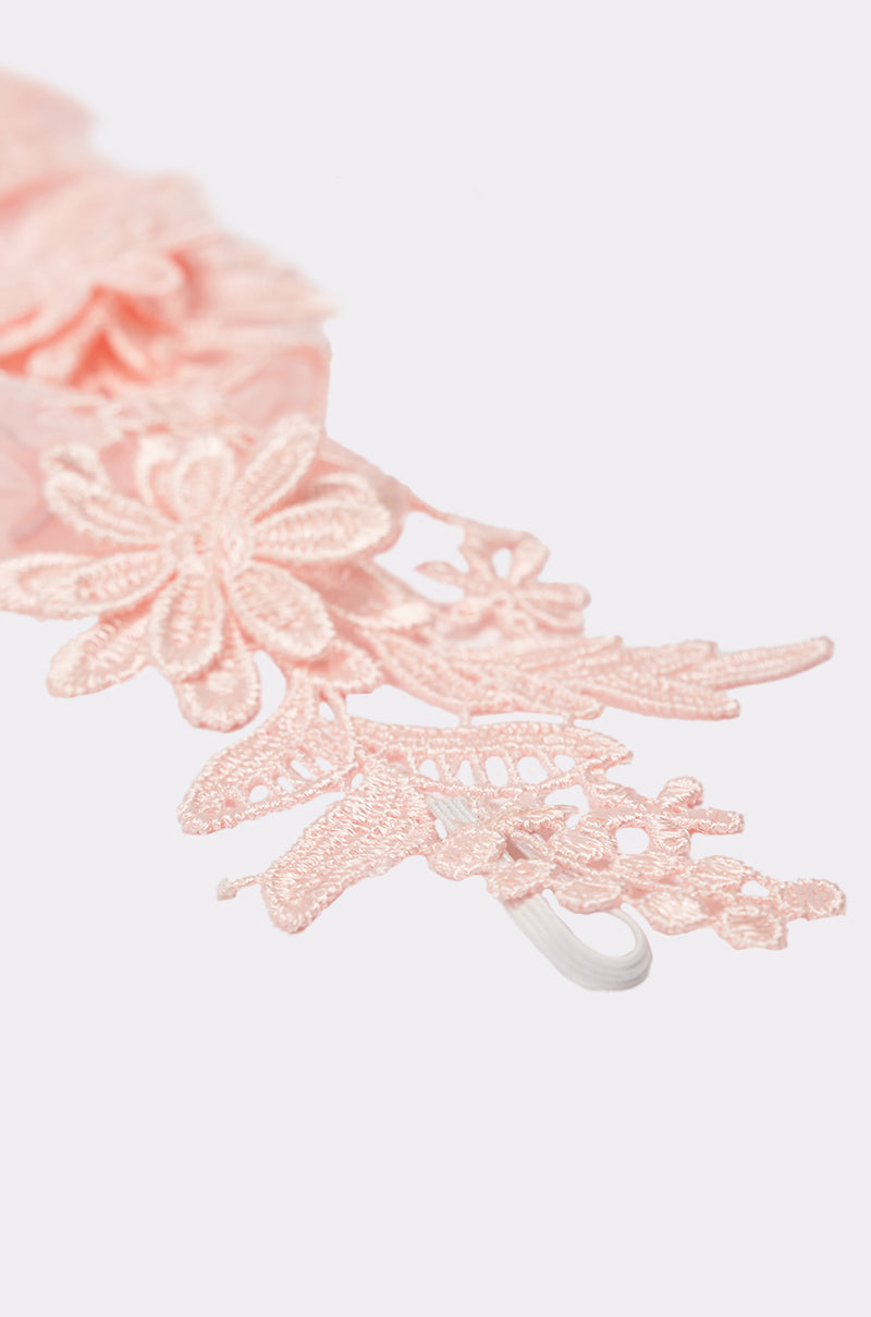 Close-up of the light pink lace trim with intricate floral patterns on ULTIMATE APPLIQUE FINGERLESS GLOVES, set against a plain white background. 2