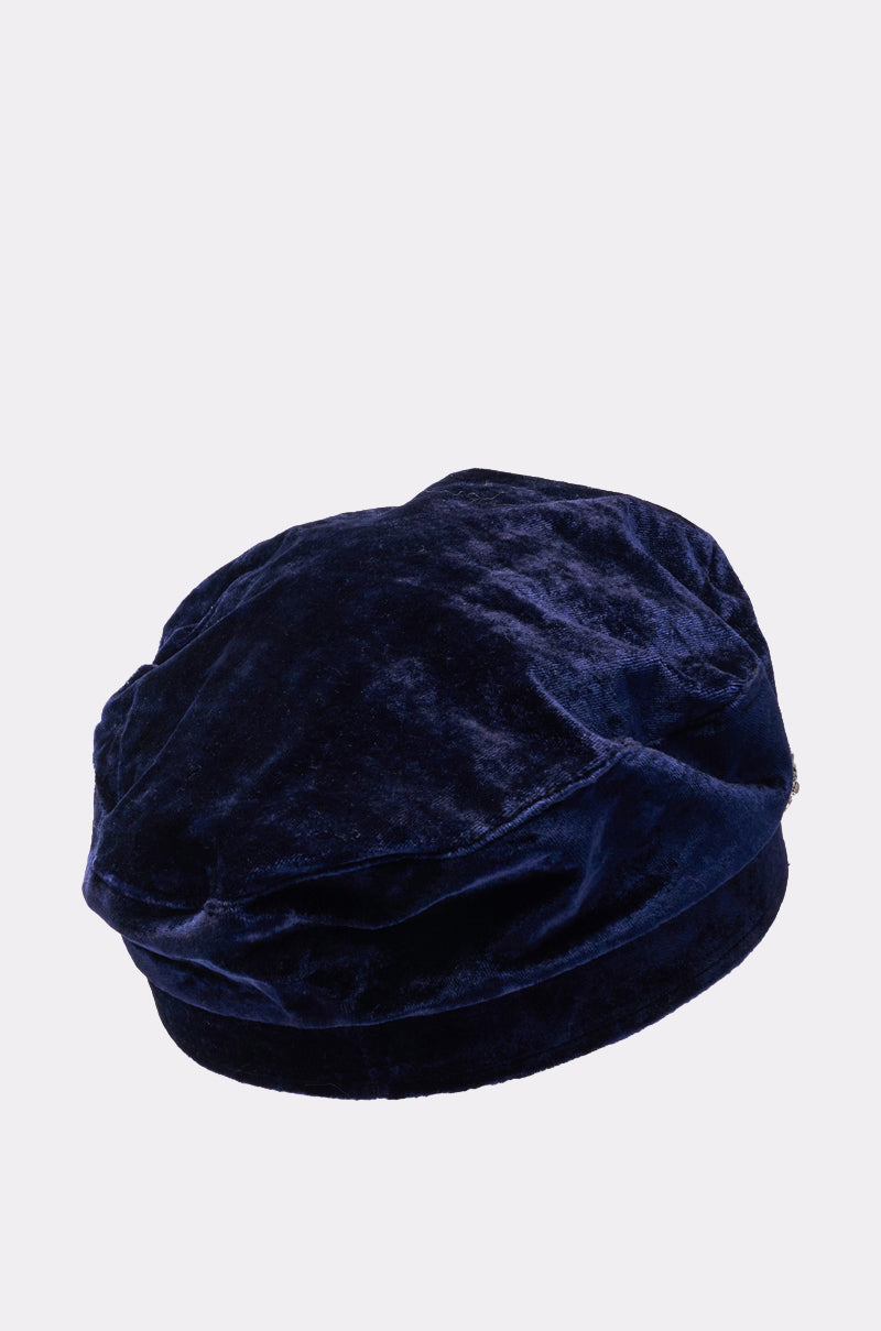 The IN THE NIGHT BRIM HAT is a navy blue faux velvet fisherman cap featuring a soft, plush texture and a decorative chain link band, shown against a plain light background. 3