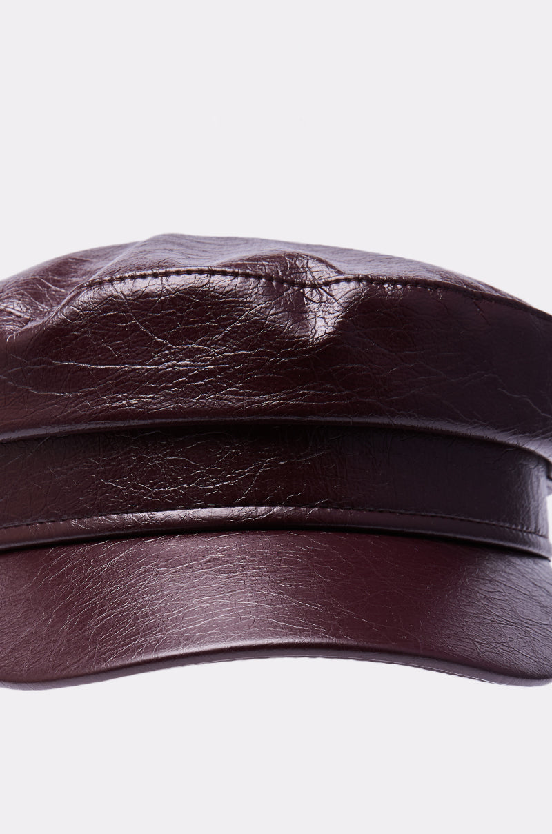 A close-up of the HERE FOR IT PU BRIM HAT, featuring a dark brown structured design with a PU brim in a newsboy style, photographed against a plain white background. 4