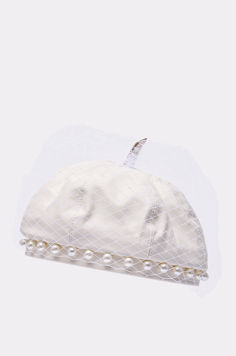 The EDITORIAL BERET is a white satin bridal hat with a short veil and pearl trim, reminiscent of a pearl-embellished beret, shown on a plain white background.