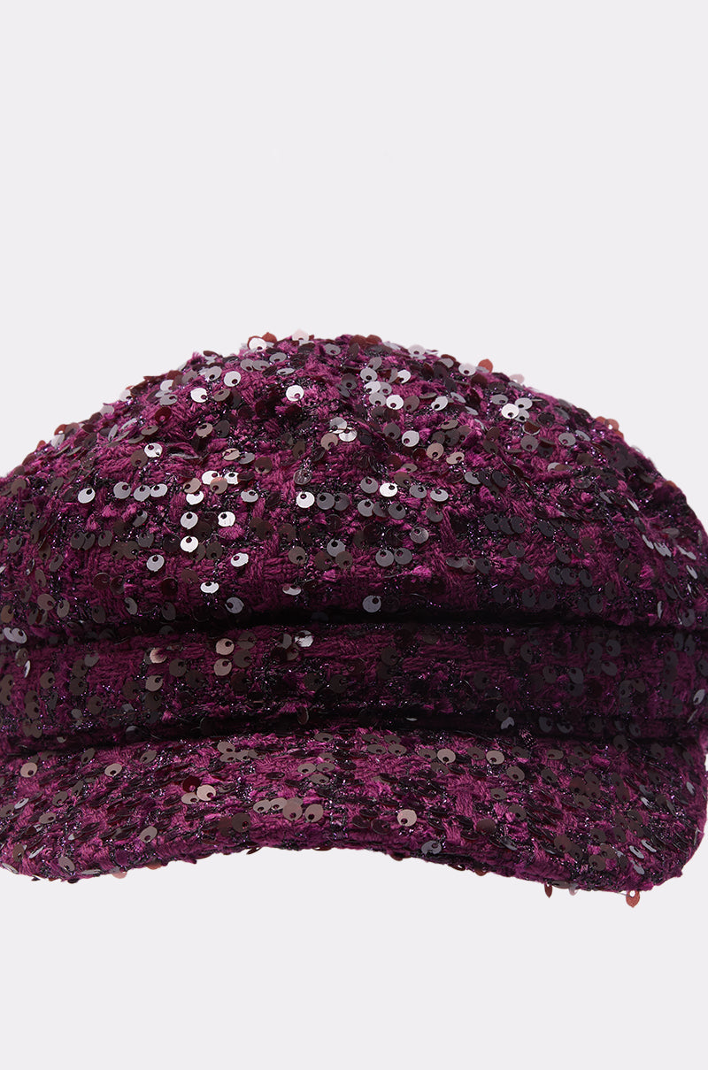 A close-up of the KARY TWEED HAT, a newsboy cap adorned with shiny dark purple sequins, set against a plain white background. 5