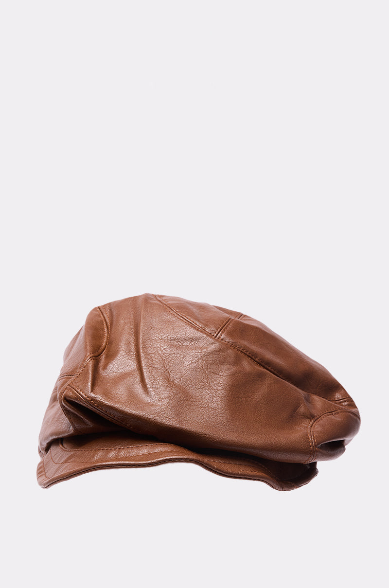 The PULL IT OFF HAT, a brown faux leather newsboy cap from AKIRA Label, is displayed on a light gray background. 4