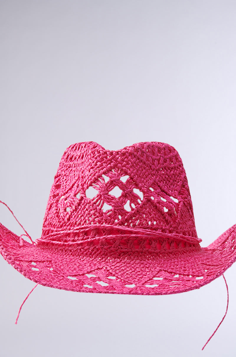 The RIDE EM STRAW COWBOY HAT, in bright pink with intricate woven patterns and a slightly curved brim, radiates true cowgirl energy against a plain white background.