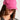 A person wearing a hot pink TOO COI SNAPBACK embellished with cat ears and small rhinestones. The individual has long brown hair and is dressed in a black outfit with gold accents. The person's face is partially visible, and they are looking slightly downward.