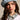 A woman with long brown hair wears the IT GURL DENIM BERET from AKIRA Label and a white shirt with a bleached denim collar, looking directly at the camera with a neutral expression against a plain background.