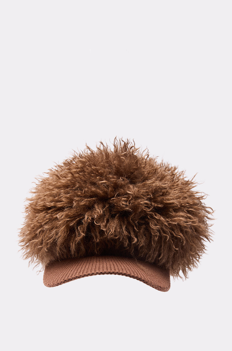 The WHOS HAIR HAT is a brown baseball cap featuring a fluffy, curly faux fur top for a playful and unique look, set against a plain, light background.
