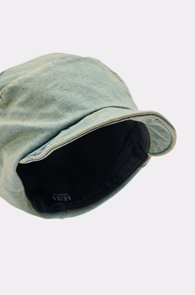 A close-up of the IT GURL SLOUCH DENIM HAT in light green denim with a black inner lining, shot from an angle highlighting the interior and brim against a plain light background.