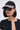A woman with a black bob wears the NAILED IT HAT, featuring pink and white trim, along with oversized black sunglasses and a black lace-trimmed top. She faces forward against a plain light background.