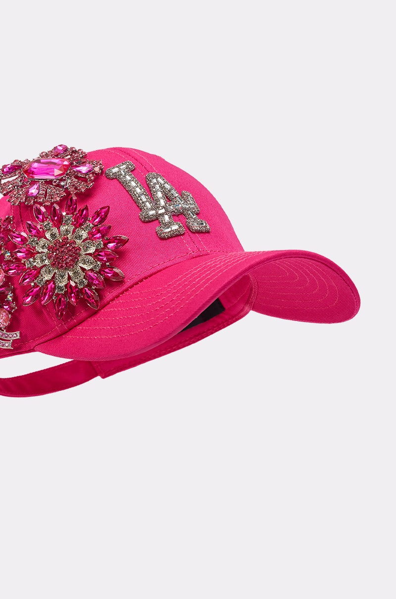 Make a statement in the VAL BROOCH HAT, a hot pink cap featuring sparkling crystal floral appliqués and a rhinestone LA logo for an eye-catching, bold finish. 4