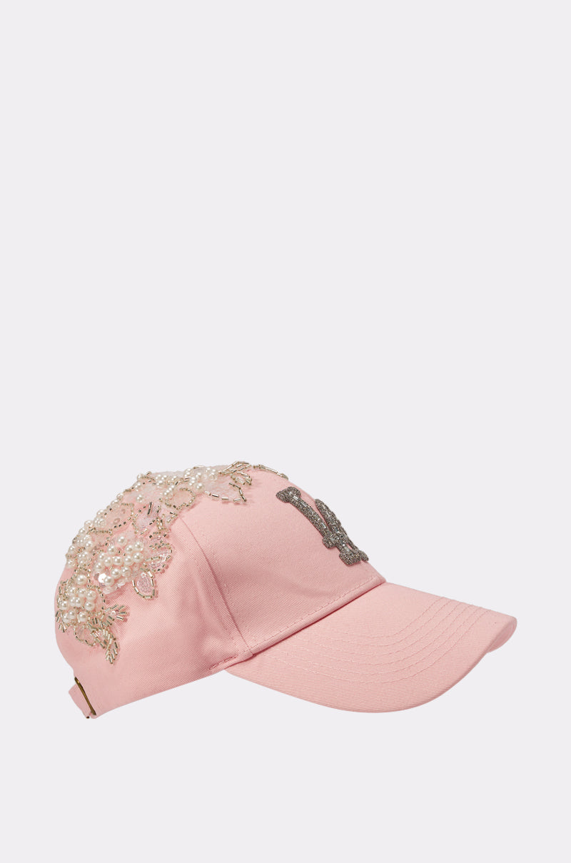 THE CITY APPLIQUE HAT is a baby pink feminine baseball cap with sparkling sequins and bead embellishments on the side and top, plus a decorative letter “B” on the front panel. 3