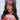A woman wears the UR STYLE ICON Plaid Brim Hat in pink and yellow, perfectly matching her purple knit sweater with colorful crochet. Her long wavy hair cascades as she gazes slightly right against a white backdrop, exuding a hint of Y2K accessory charm.