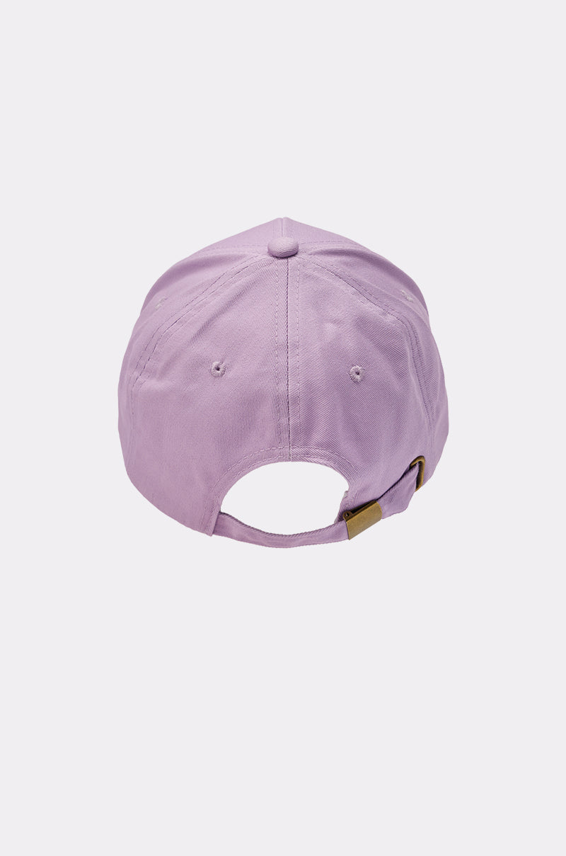 The IN THE CITY APPLIQUE HAT is a lavender baseball cap displayed from the back, with an adjustable strap and metal clasp, plus two small ventilation holes on each side. The background is plain white. 4