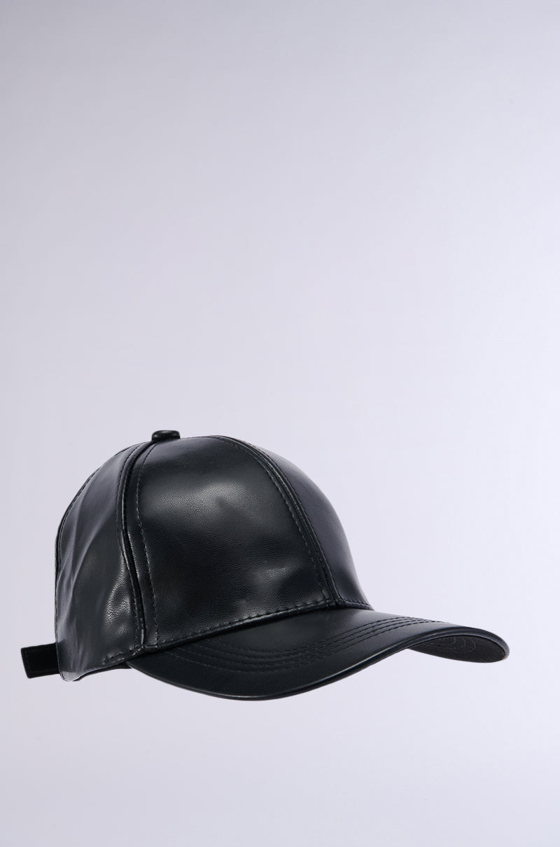 The PU SNAPBACK, a black faux leather baseball cap with detailed stitching on the panels and visor, is shown against a plain, light gray background. The cap features a slightly curved brim and an adjustable strap at the back. 3