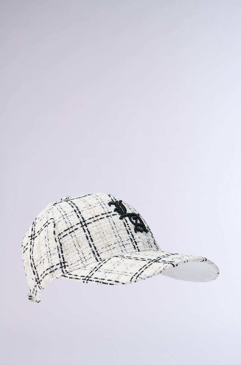 The COME TO ME HAT is a white baseball cap with a black plaid tweed pattern and a black embroidered AKIRA Label logo on the front, displayed on a plain light gray background. 2
