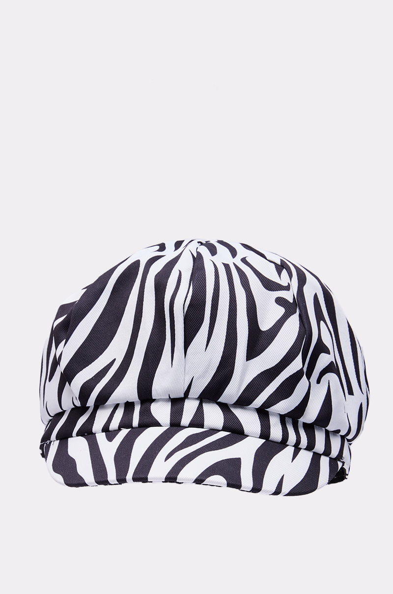 The ZEBRA LUXE BRIM HAT, a black and white zebra print newsboy cap ideal for festivals, is displayed against a plain light background. 2