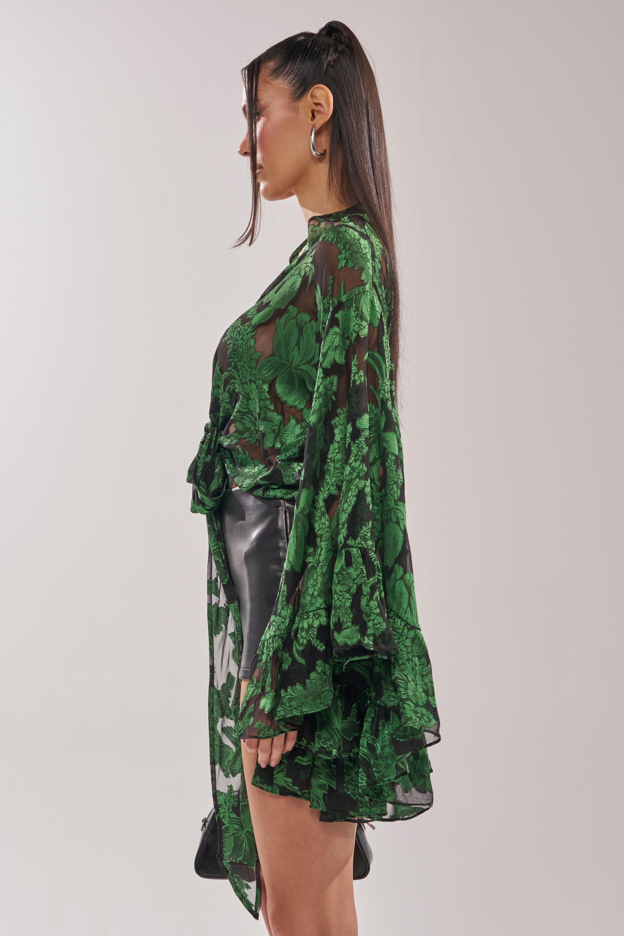 A woman with long brown hair in a high ponytail stands in profile against a plain background, wearing the IN THE FEELS LACE BLOUSE with wide sleeves and a black skirt. 4