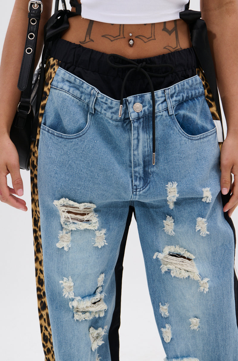 Wearing WILDIN' OUT DENIM TRACKPANTS with leopard-print panels, a white crop top, a belly button piercing, visible tattoos on the midriff, and a black bag strap over one shoulder. 7