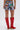 Wearing the KISS MY PATCH DENIM SHORT with vibrant patches and embroidery, paired with tall red cowboy boots with white stitching. Photo is taken from behind against a plain background.