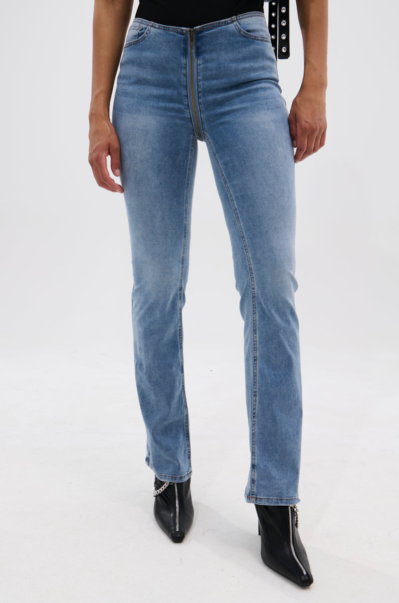 A person wearing the TOO GOOD TO BE TRUE LOW RISE DENIM FLARE PANT in light blue, paired with black pointed-toe ankle boots. The photo is cropped from the waist down against a plain white background.