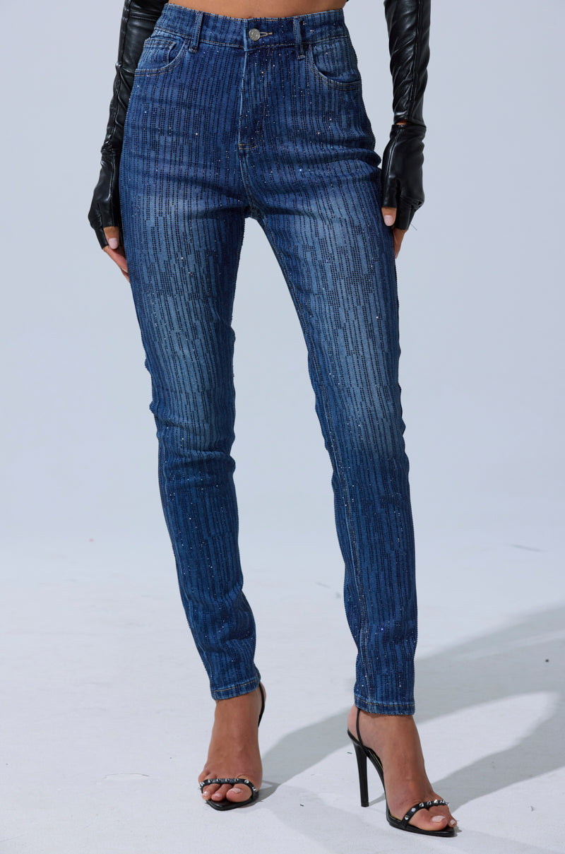 A person wearing SHINING STAR RHINESTONE WIDE LEG PANT with vertical glittery stripes, black open-toe high heels, and black leather gloves stands against a plain light background.