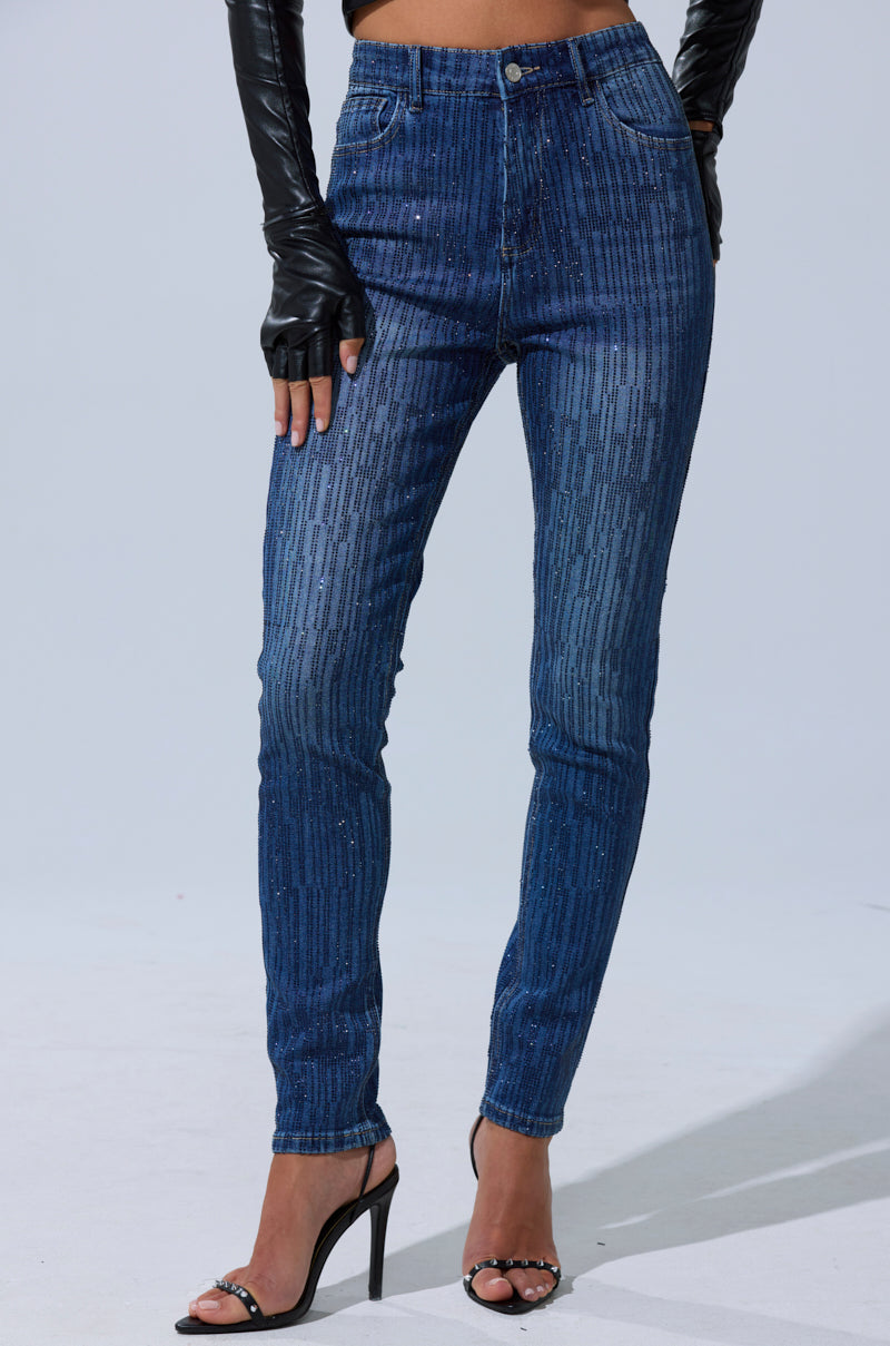 A person wears SHINING STAR RHINESTONE WIDE LEG PANT with black high heels and long, fingerless gloves, set against a plain, light-colored background.