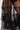 A close-up of a person stylishly layering the PERFECT FOR LAYERING TULLE MAXI DRESS over black bottoms, holding a small sparkly handbag. The focus is on their lower body and hand against a plain background.