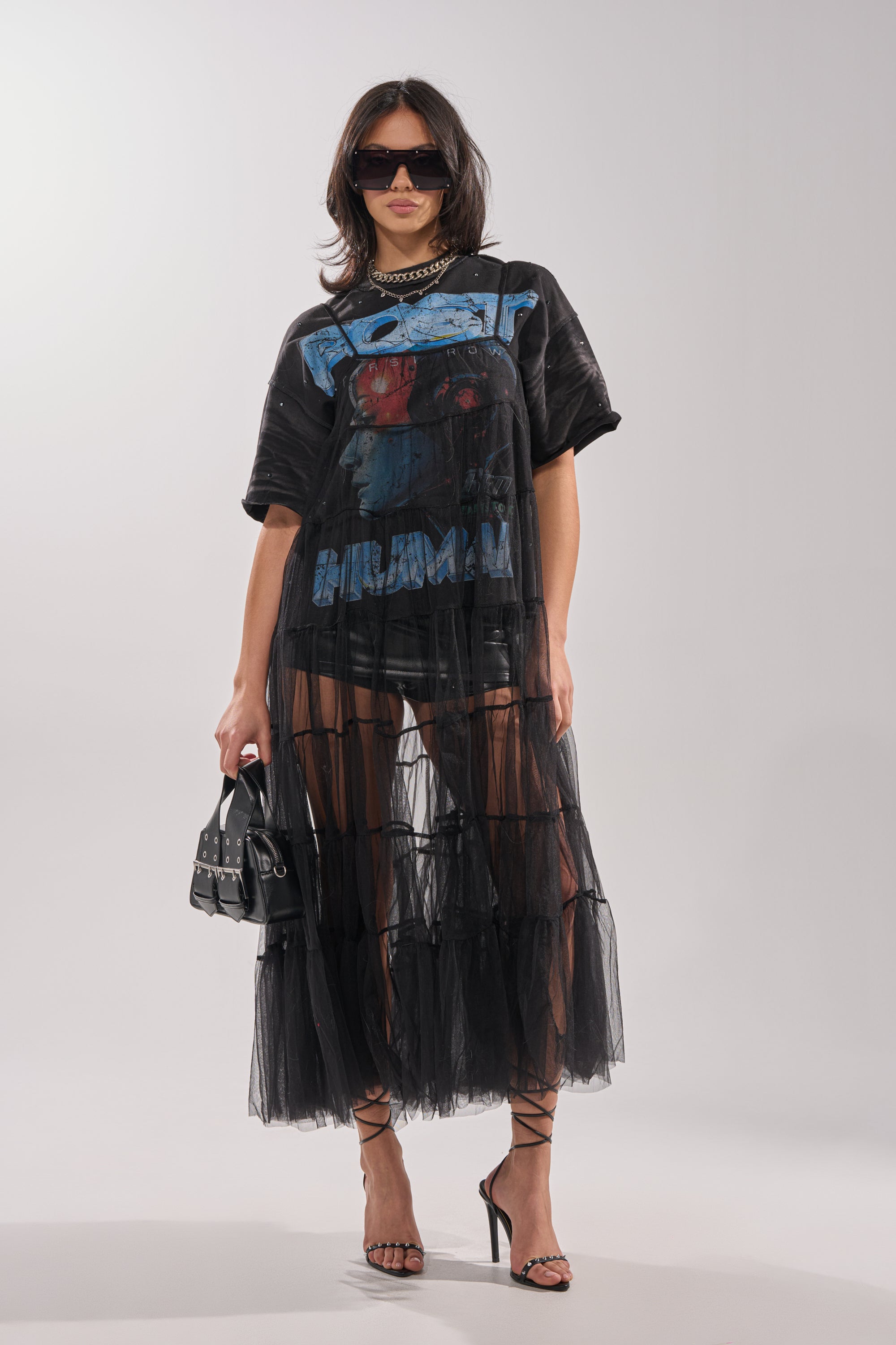 A woman wears the PERFECT FOR LAYERING TULLE MAXI DRESS over black underwear, paired with a black graphic tee, large sunglasses, chunky necklace, small black handbag, and strappy heels, standing against a plain background. 7