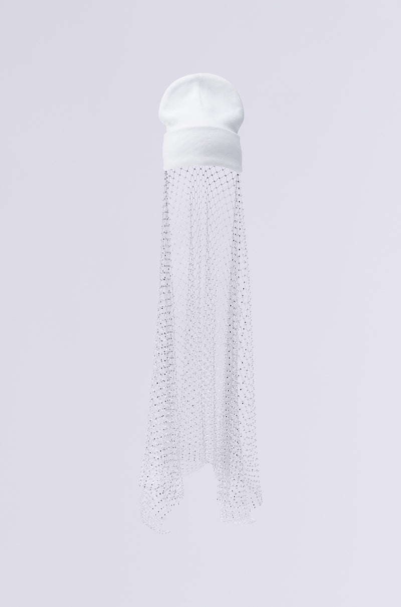 Product Name: TRAIL OF RHINESTONES BEANIE A white beanie adorned with a translucent veil that flows elegantly from the back. The veil features delicate dot patterns and subtle rhinestones, making it a stylish and unique knit accessory against a light gray background. 5