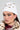 Wearing the ASAP Vibes Embellished Beanie, a person confidently showcases their AKIRA Label style. Adorned with jewel-like embellishments, the beanie sits perfectly atop their head. Paired with large hoop earrings and bold eye makeup, they radiate style and self-assurance in a fur-trimmed ensemble.